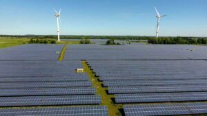 Solarpark, dahinter Windturbinen in Norddeutschland